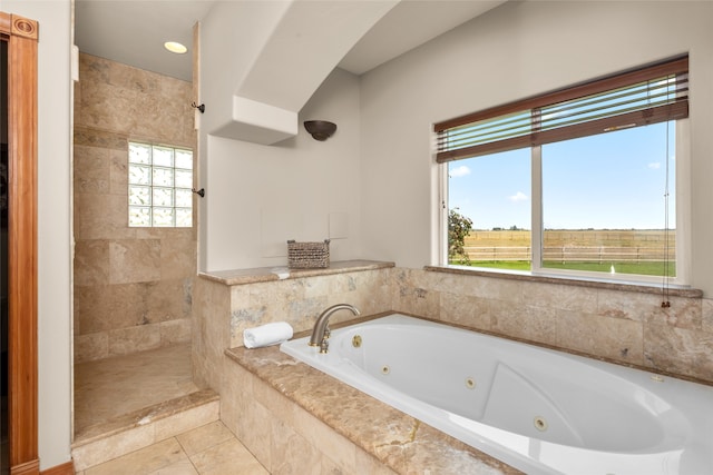 bathroom featuring tile patterned flooring, a healthy amount of sunlight, and plus walk in shower