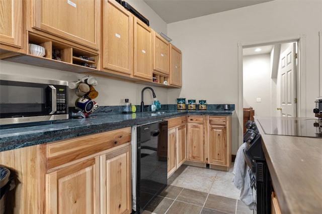 kitchen with dark stone countertops, light brown cabinets, sink, and stainless steel appliances