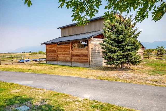 exterior space with a mountain view, a rural view, and an outbuilding