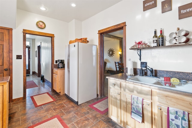 kitchen featuring light brown cabinetry, sink, and white refrigerator