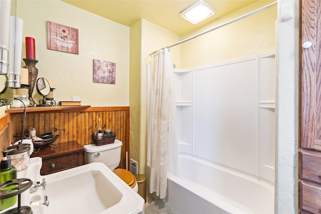 full bathroom featuring toilet, shower / bath combination with curtain, and sink