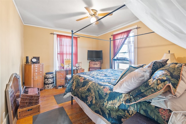 bedroom with ceiling fan, ornamental molding, and wood-type flooring