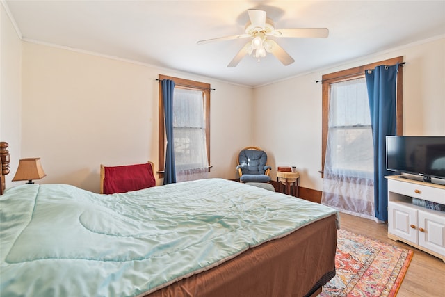 bedroom with light hardwood / wood-style floors, ceiling fan, and crown molding