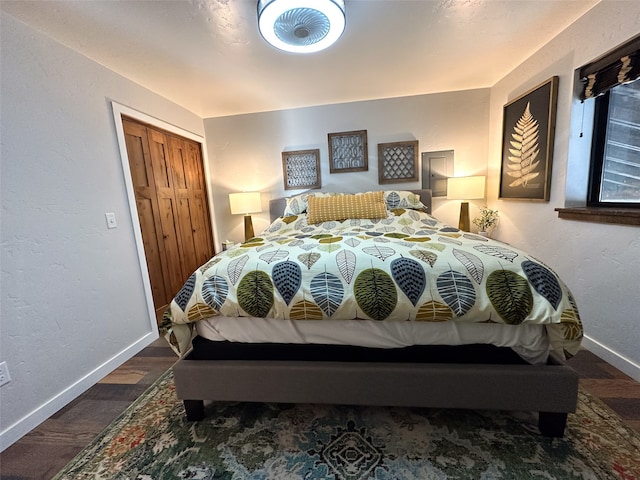 bedroom with dark wood-type flooring and a closet