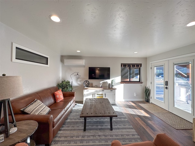 living room with hardwood / wood-style floors, a wall unit AC, and french doors