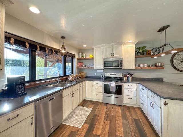 kitchen with stainless steel appliances, hanging light fixtures, sink, and dark wood-type flooring