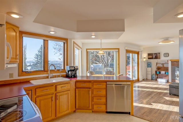 kitchen with range, sink, stainless steel dishwasher, light wood-type flooring, and decorative light fixtures