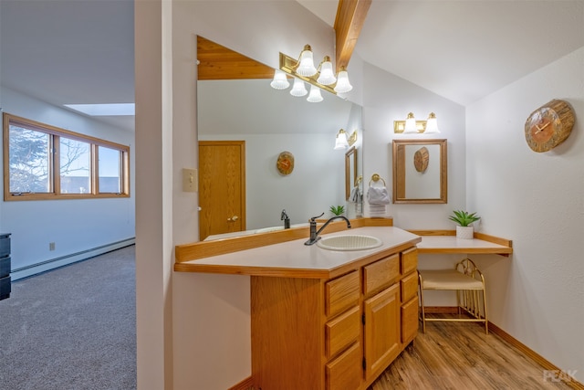 bathroom with vaulted ceiling with skylight, vanity, hardwood / wood-style flooring, and a baseboard heating unit