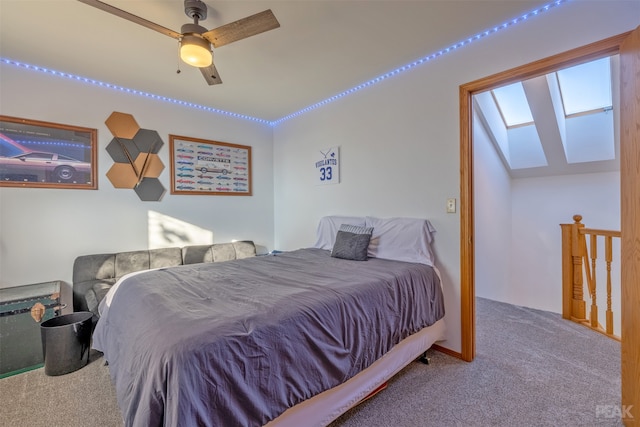 bedroom with lofted ceiling with skylight, carpet, and ceiling fan