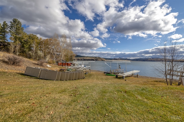 view of yard featuring a dock and a water view