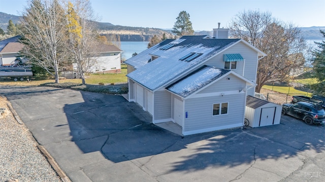 exterior space featuring a garage and a water and mountain view