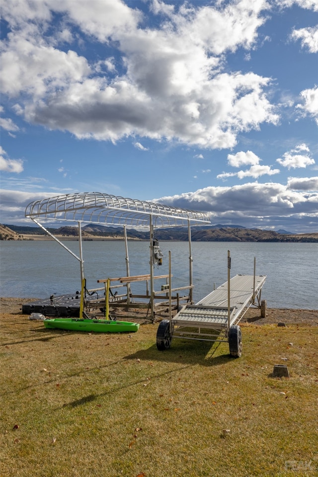 dock area with a water view and a lawn