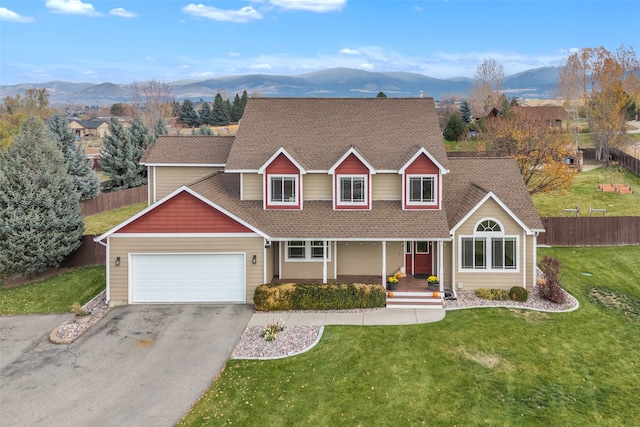 view of front of house featuring a garage, a front yard, and a mountain view