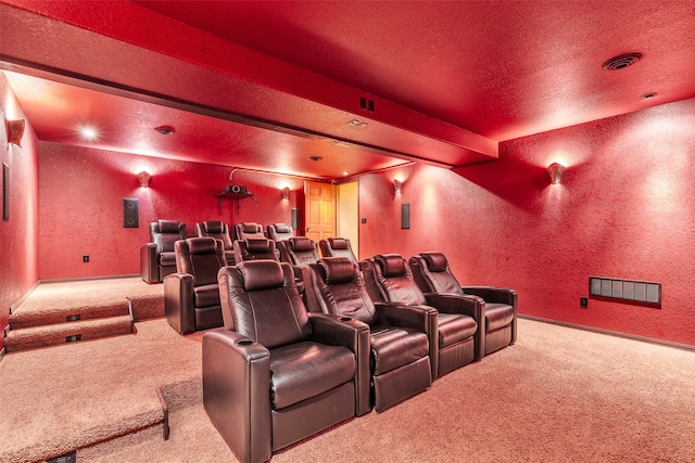 carpeted home theater with beamed ceiling and a textured ceiling