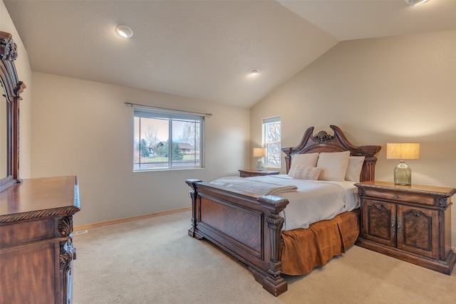 bedroom with light colored carpet and lofted ceiling