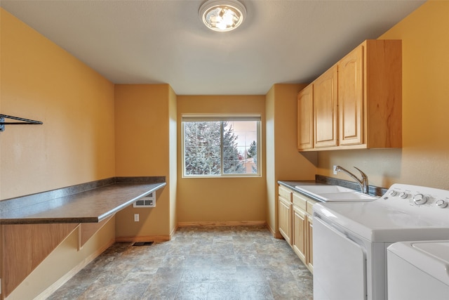 clothes washing area featuring cabinets, washer and dryer, and sink