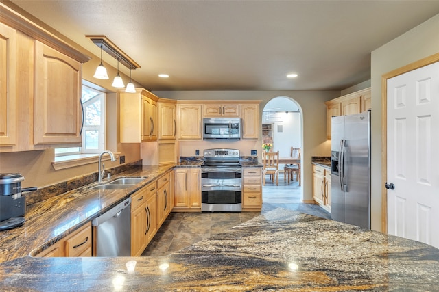 kitchen featuring light brown cabinetry, appliances with stainless steel finishes, sink, and hanging light fixtures