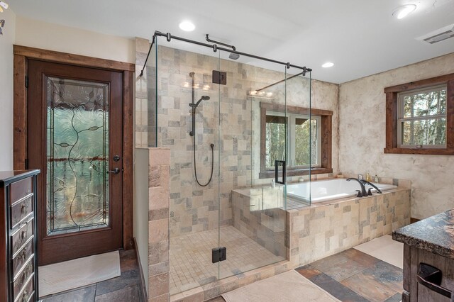 full bathroom with a stall shower, plenty of natural light, visible vents, and stone tile floors