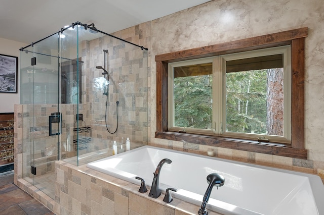 full bathroom with a stall shower, stone finish flooring, and a bath