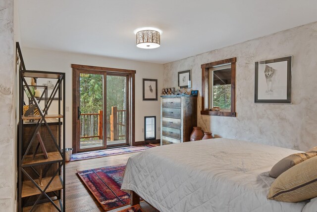 bedroom featuring wood finished floors and access to exterior