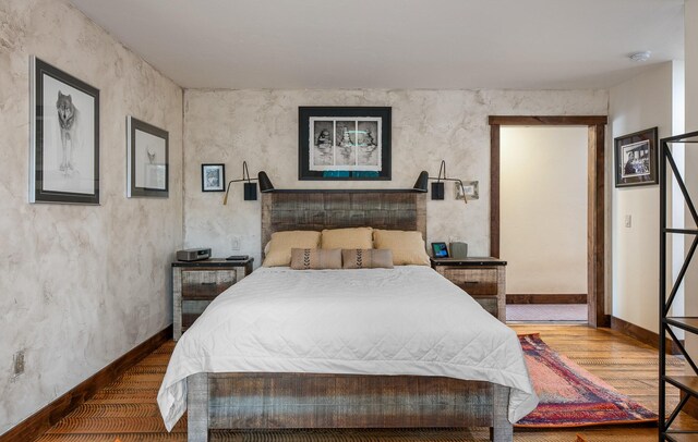 bedroom featuring baseboards and wood finished floors