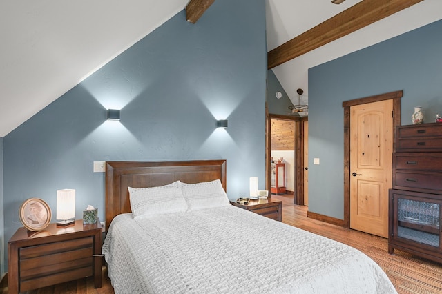 bedroom featuring vaulted ceiling with beams, baseboards, and wood finished floors