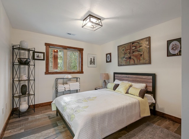 bedroom with dark wood-style flooring, visible vents, and baseboards