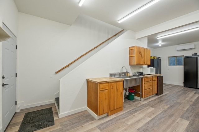 kitchen featuring white microwave, a wall unit AC, light countertops, fridge, and open shelves