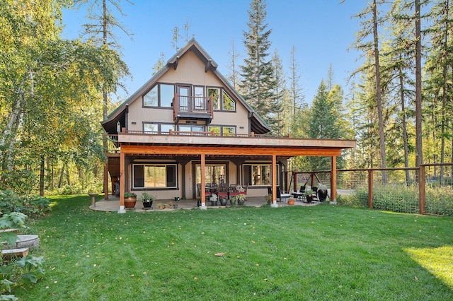 back of property with a patio, a yard, fence, and a balcony