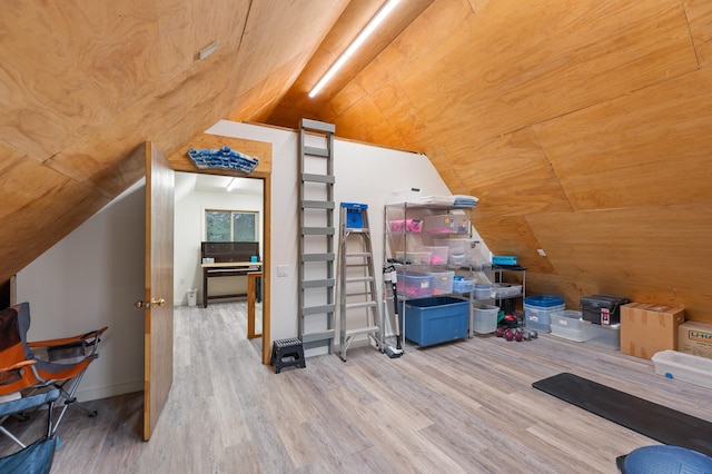 additional living space featuring light wood-style flooring, baseboards, and vaulted ceiling