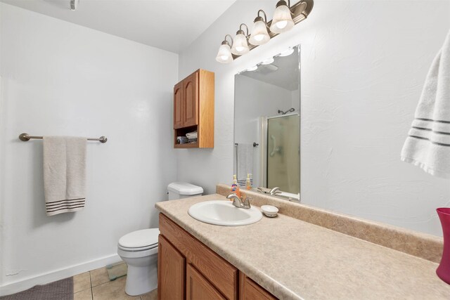 bathroom featuring vanity, walk in shower, tile patterned flooring, and toilet