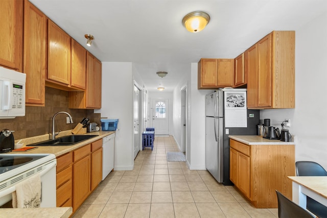 kitchen with backsplash, white appliances, sink, and light tile patterned flooring