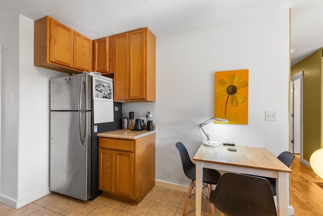 kitchen with light tile patterned flooring and stainless steel fridge