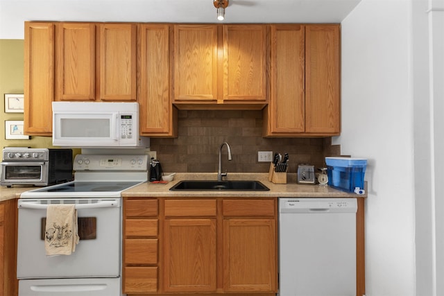 kitchen with white appliances, sink, and tasteful backsplash