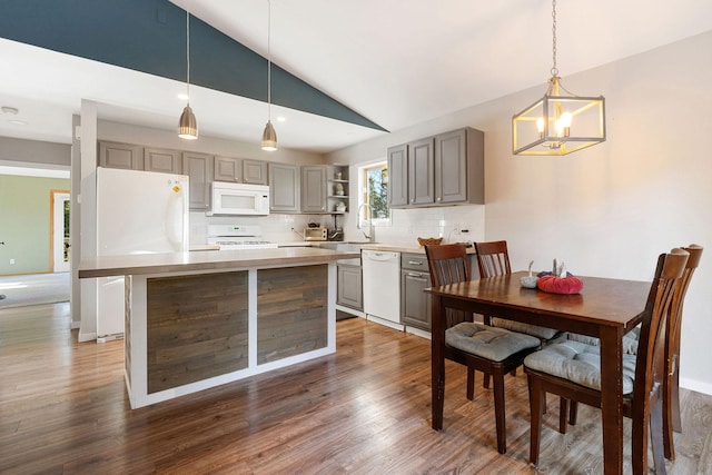 128 Ledgewood Dr, Bigfork, MT 59911 - kitchen with white appliances, gray cabinetry, vaulted ceiling, a chandelier, and open shelves