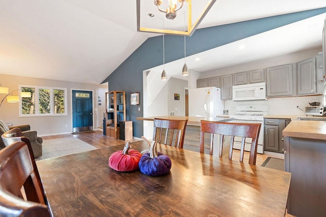 128 Ledgewood Dr, Bigfork, MT 59911 - dining room with lofted ceiling, a chandelier, light wood-type flooring, and recessed lighting