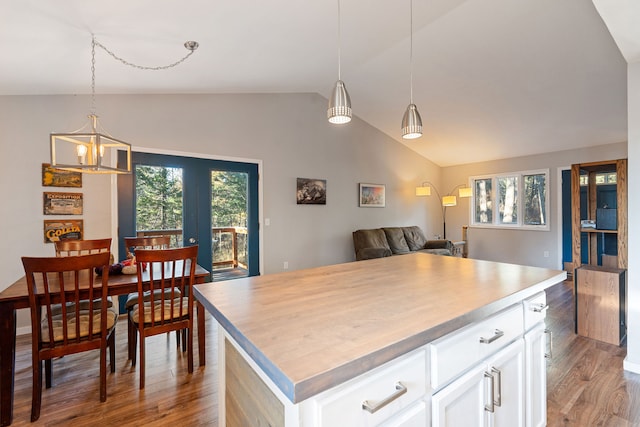 kitchen featuring white cabinetry, a center island, wood-type flooring, lofted ceiling, and decorative light fixtures