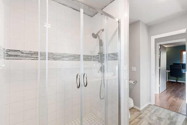 bathroom featuring hardwood / wood-style flooring, toilet, and an enclosed shower