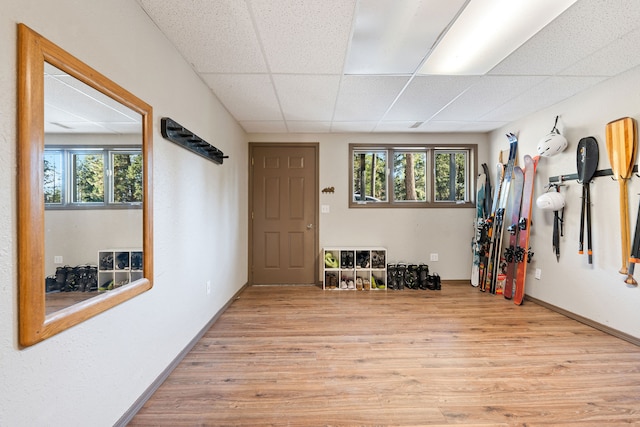 interior space with a drop ceiling and light hardwood / wood-style flooring