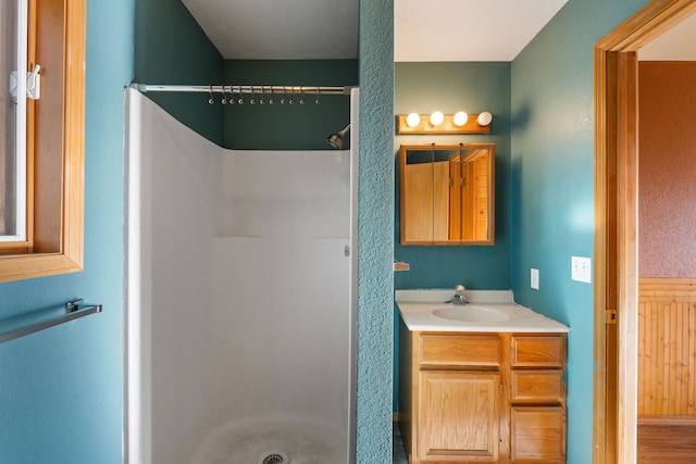 bathroom featuring vanity, wood-type flooring, and walk in shower