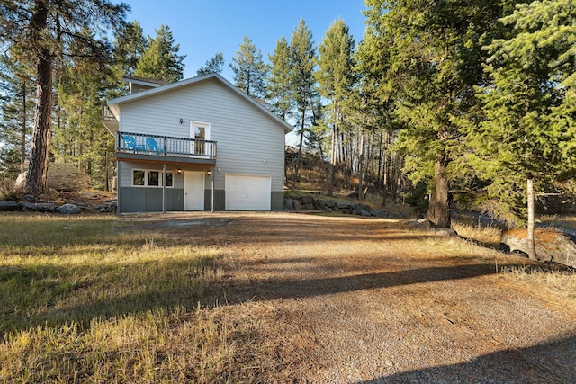 128 Ledgewood Dr, Bigfork, MT 59911 - back of property featuring a garage, driveway, and a wooden deck