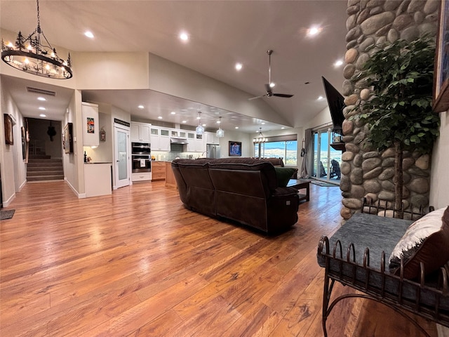 living room with high vaulted ceiling, light wood-type flooring, and ceiling fan