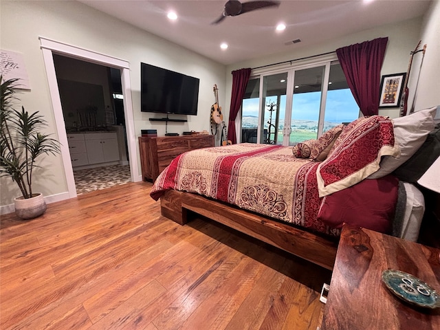 bedroom featuring ensuite bathroom, ceiling fan, light wood-type flooring, and access to outside