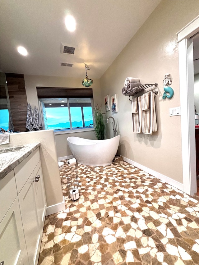 bathroom with a tub to relax in and vanity