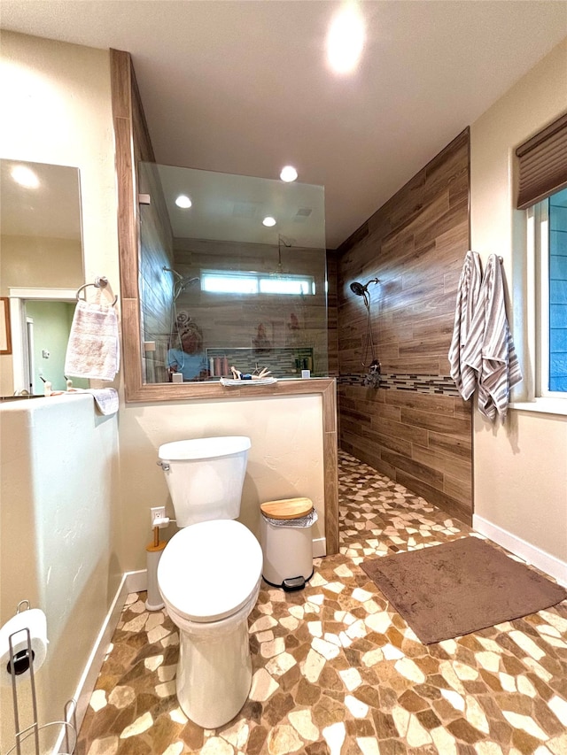 bathroom with tiled shower and toilet