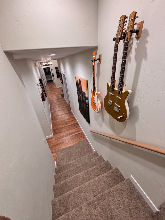 staircase featuring wooden walls and concrete floors