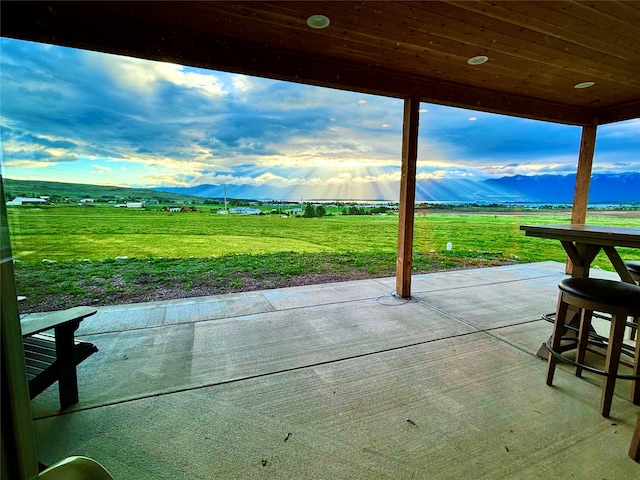 view of patio / terrace with a mountain view and a rural view