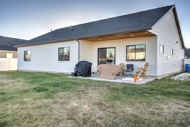 rear view of property featuring a yard and a patio area