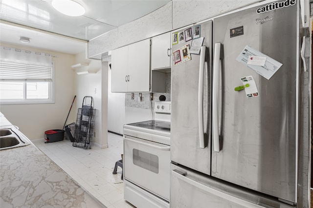 kitchen with white cabinets, stainless steel fridge, sink, and white electric range oven