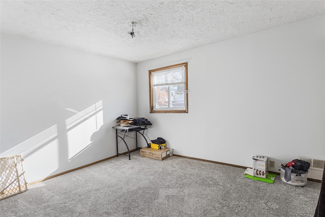 spare room with a textured ceiling and carpet flooring